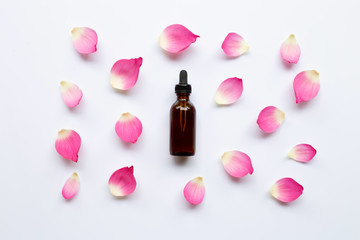 Lotus essential oil with lotus petals on white background.