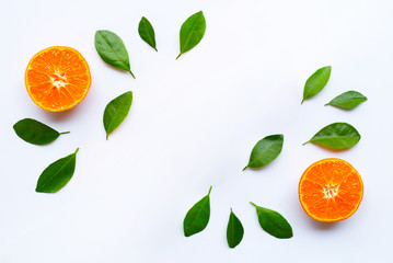 Fresh orange citrus fruit with green leaves on white.