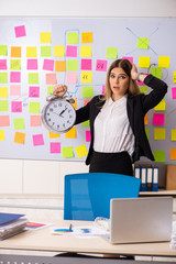 Young beautiful businesslady in conflicting priorities concept 