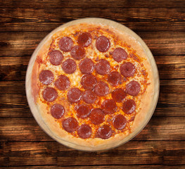 Isolated pizza pepperoni on a wooden background.