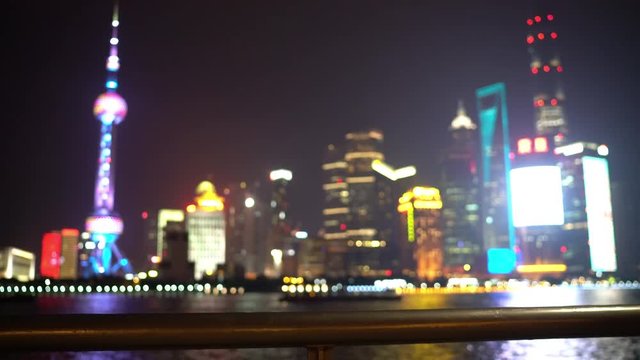 Shanghai the Bund China background video shot at night with famous skyline. Focus on foreground, blurry out of focus.