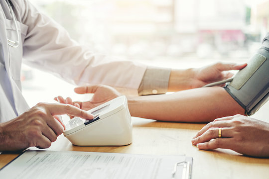 Doctor Measuring arterial blood pressure man patient on arm Health care in hospital