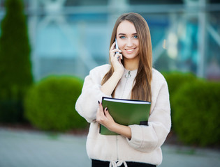 Businesswoman talking on mobile phone in Lviv cityscape background