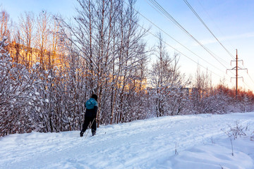 Fototapeta na wymiar Male skier rides in the winter park at sunset