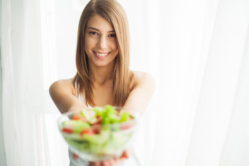 Obraz na płótnie Canvas Healthy salad. Young beautiful woman eating salad