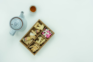 Table top view Lunar New Year & Chinese New Year concept background.Flat lay sweet dessert & cup of tea on modern rustic white wooden.Copy space for mock up text.Meal set for take break time.