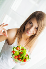 Healthy salad. Young beautiful woman eating salad