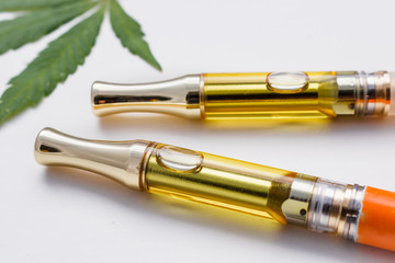 Full Gram THC/CBD Concentrated Oil In Cartridges Closeup Marijuana Leaf On White