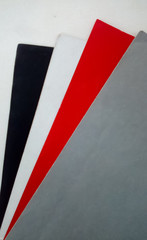 Cartulinas de color negro, blanco, rojo y gris en fondo blanco