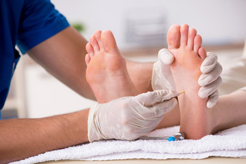 Podiatrist treating feet during procedure