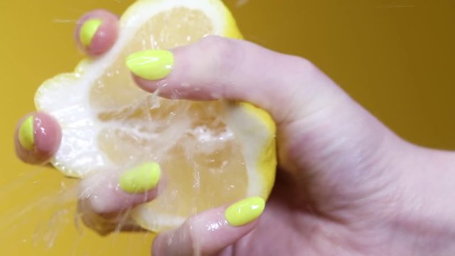 Fresh lemon squeezed in slow motion as juice erupts