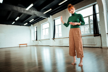 Red-haired professional yoga instructor with hair bun looking serious