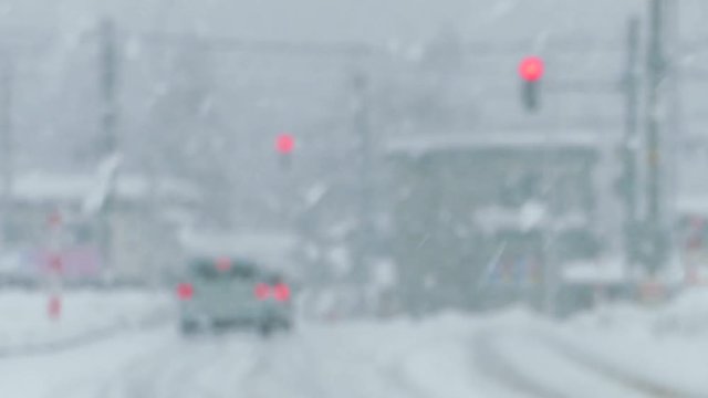 雪道を走行する自動車　交差点　信号機　冬　交通　イメージ