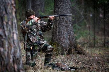 Naklejka premium hunter with a gun in the forest cures prey