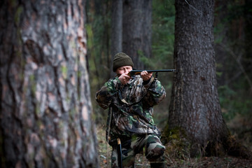 Naklejka premium hunter with a gun in the forest cures prey