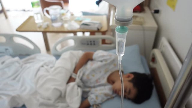 Little boy get sick from influenza need to be admitted to hospital with saline intravenous (iv)  in-line hand pressure