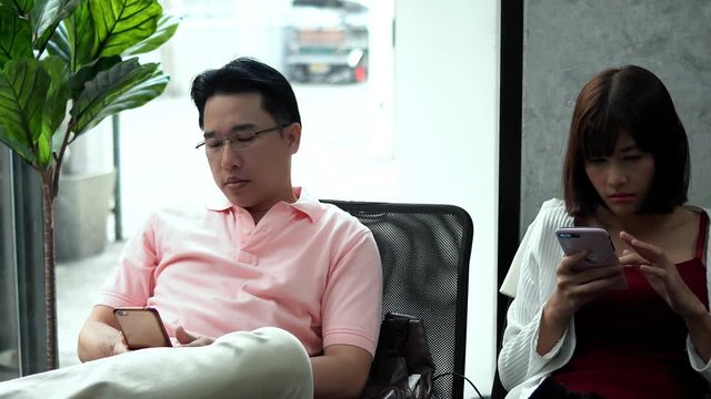 The young couple used smartphone ignoring each other