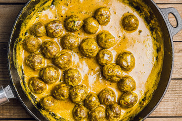 Meatballs in creamy sauce in a frying pan. Selective focus. Shallow depth of field. 