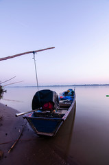fisherman long tail boat in sunrise Khong river between Thailand and Lao 