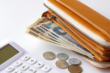 財布の中のお金と電卓　節約　貯金　浪費