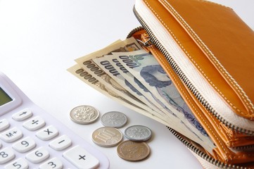 財布の中のお金と電卓　節約　貯金　浪費