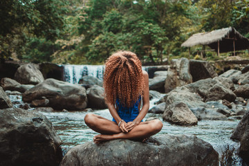 young woman sitting on a rock