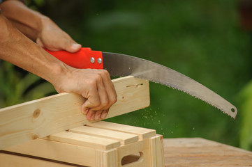 the Men measures the product and parts for the of  wooden box.