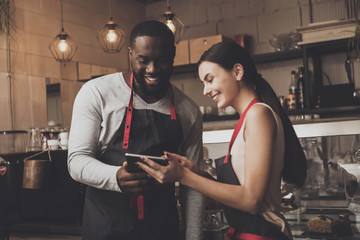 Barista man and woman looking at a tablet