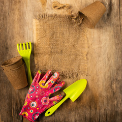 Preparing for spring to transplant plants. Pot, shovel gloves dark wooden rustic background.