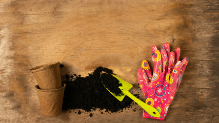 Preparing for spring to transplant plants. Pot, shovel gloves dark wooden rustic background.