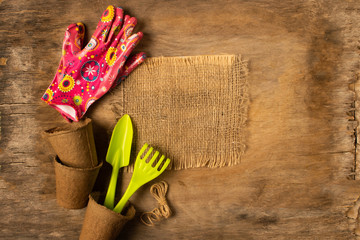 Preparing for spring to transplant plants. Pot, shovel gloves dark wooden rustic background.