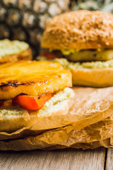 Hawaiian vegan burger with grilled pineapple, guacamole and grilled bell pepper. Selective focus. Shallow depth of field.