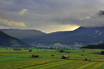 Summer of very large farm with the village and Mt. Zugspitze on the sunrise with fog , Ehrwald, Wetterstein mountain range at Biberwier, Tyrol, Austria 