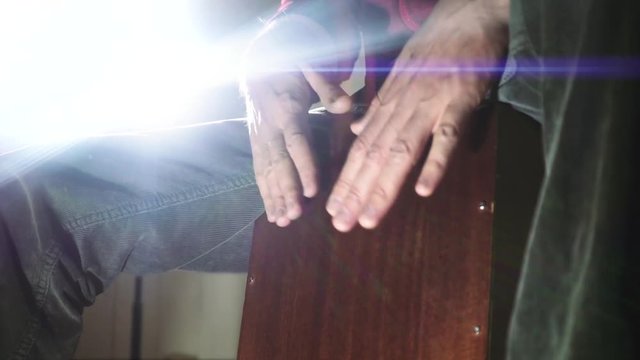 Detail of a percussionist male hands while playing flamenco drumbox. Slow motion