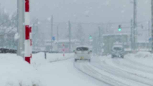 雪道を走行する自動車　交差点付近　冬　交通　イメージ