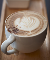 Cappuchino coffee cup at the wooden table