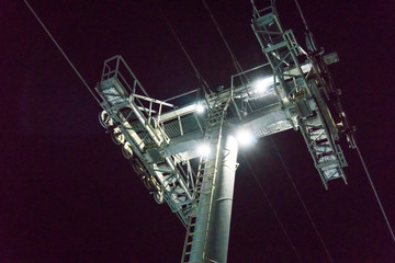 Cable car lift at ski resort. Night skiing from the mountains.