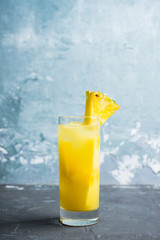 Fresh pineapple beverage on rustic background. Selective focus. Shallow depth of field.