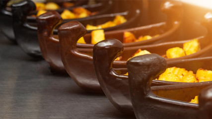 Restaurant dish of a boat with potatoes in a golden crust fried in a deep fryer. close-up, sun