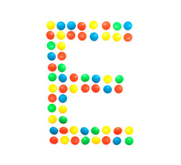 Multi-colored vitamins pills that are lined with the letter Vitamin E, close-up