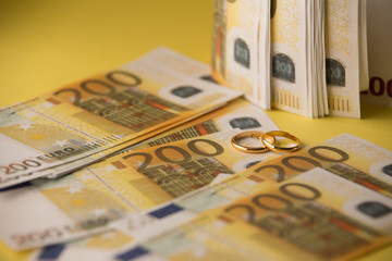 Golden wedding rings on banknotes background. Marriage of convenience