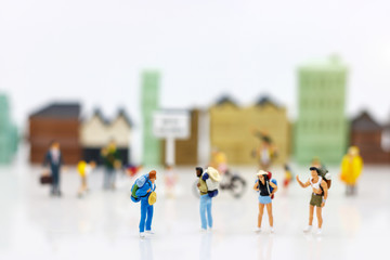 Miniature people: Traveller with backpack walking on the path of tourism. Travel, explore and adventure concept