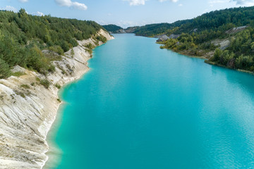 Fototapeta na wymiar An old gypsum quarry filled with blue and pure water. Aerial view, from top to bottom