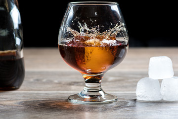 Brandy glass and falling ice splashes