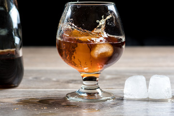 Brandy glass and falling ice splashes