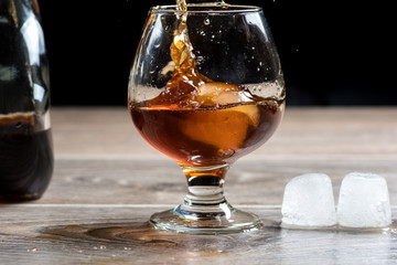 Brandy glass and falling ice splashes