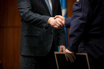 Business award. Mature businessman congratulates younger employee standing in front of the happy...