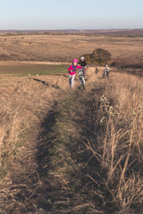 Mother and kids on their bikes go up the hill