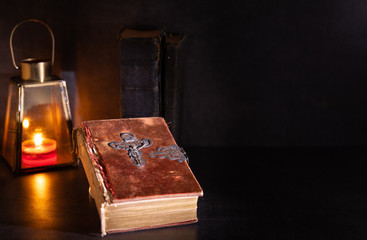 old bible on a table with candle light