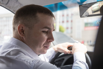 Young man in white shirt in car